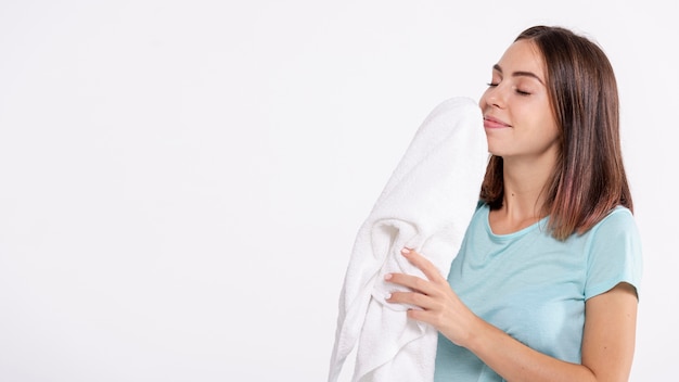 Free photo medium shot woman smelling clean towel