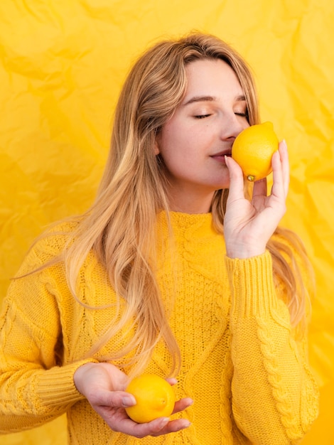 Medium shot woman smelling lemon