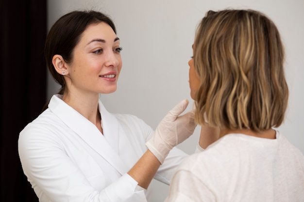 Foto gratuita donna del colpo medio all'appuntamento del medico sorridente