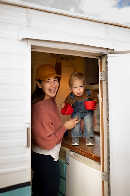 Free photo medium shot woman and smiley kid with mugs