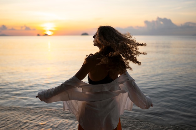 Foto gratuita donna di tiro medio che trascorre una giornata da sola sulla spiaggia