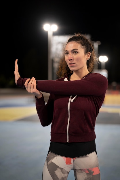 Free photo medium shot woman stretching arm