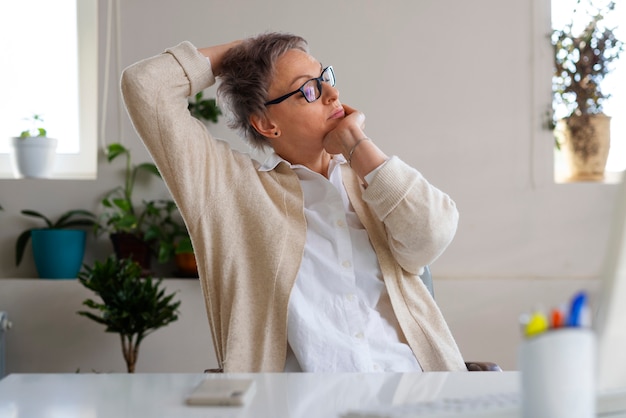 Medium shot woman stretching at desk