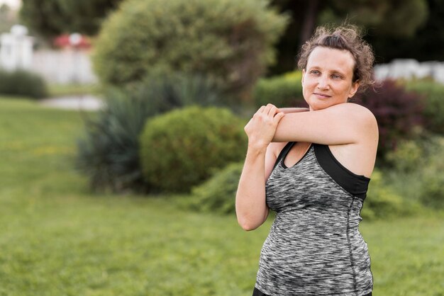 Medium shot woman stretching her arm