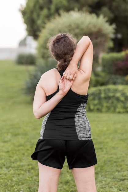 Free photo medium shot woman stretching her back