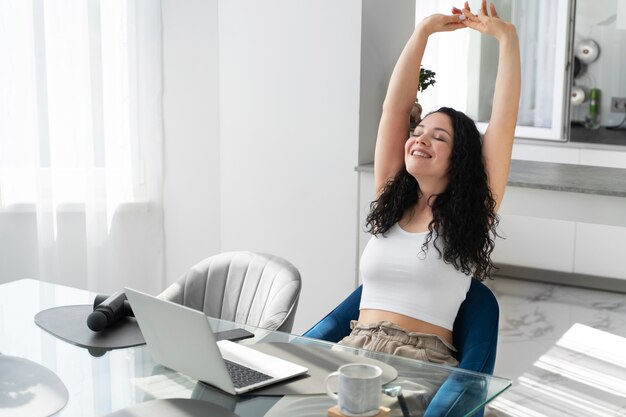 Medium shot woman stretching indoors