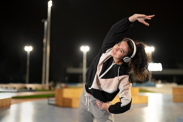 Free photo medium shot woman stretching at night