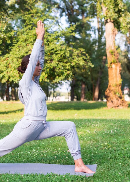 Medium shot woman stretching outdoors