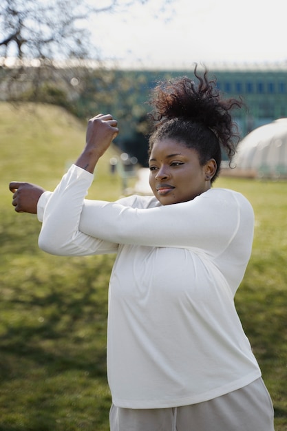 Medium shot woman stretching outdoors