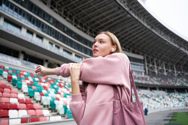 Medium shot woman stretching outdoors