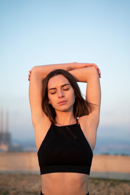 Medium shot woman stretching outside