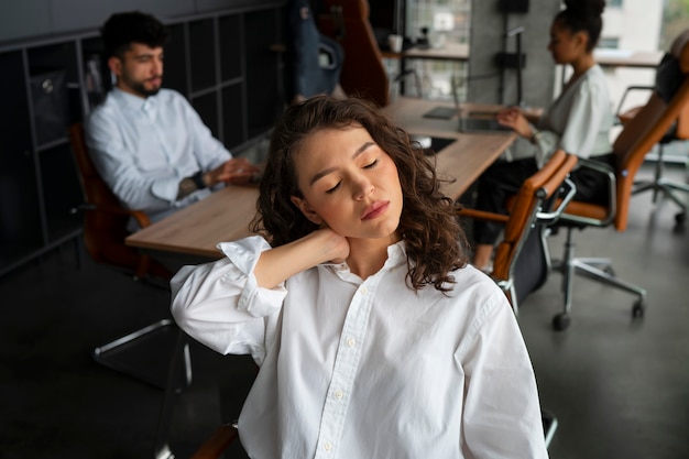 Free photo medium shot woman stretching at work