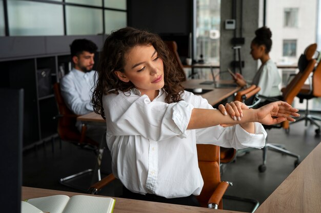 Medium shot woman stretching at work