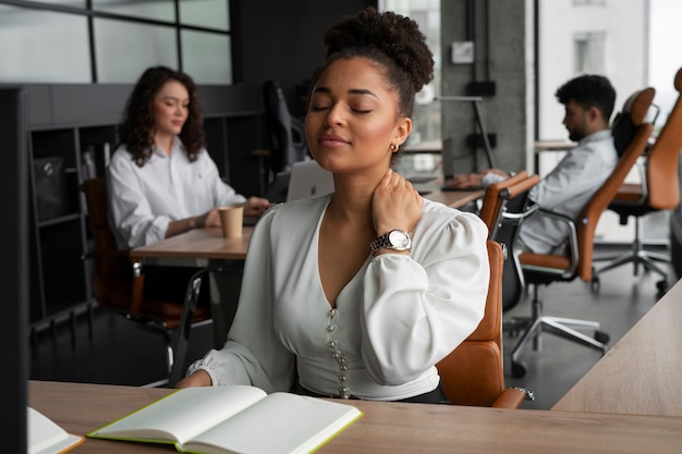 Free photo medium shot woman stretching at work