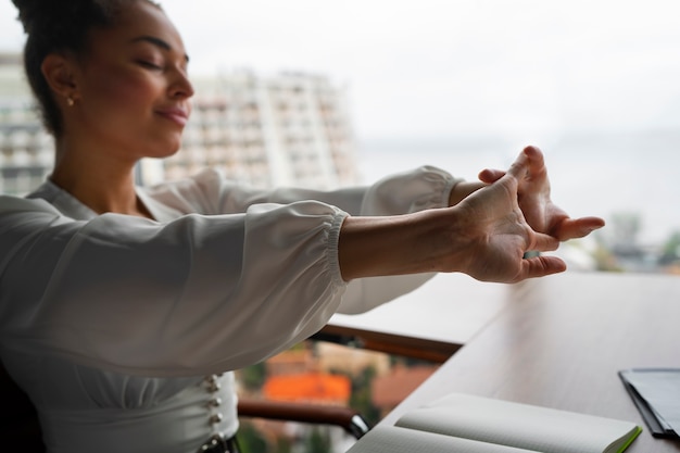 Medium shot woman stretching at work