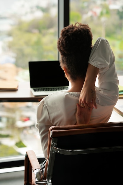 Medium shot woman stretching at work