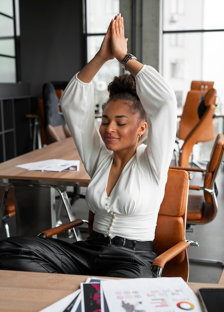 Free photo medium shot woman stretching at work