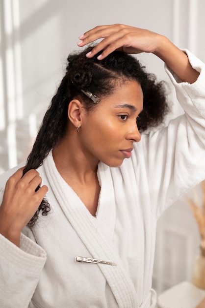 Foto gratuita donna con colpo medio che si pettina i capelli