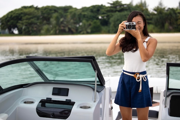 ボートで写真を撮るミディアムショットの女性