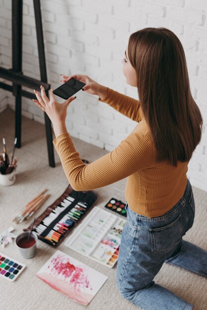 写真を撮るミディアムショットの女性