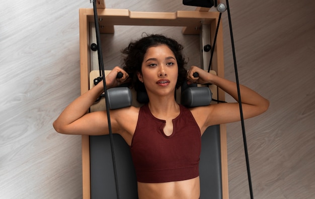 Free photo medium shot woman taking  pilates reformer class