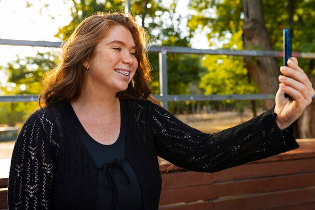 Medium shot woman taking selfie