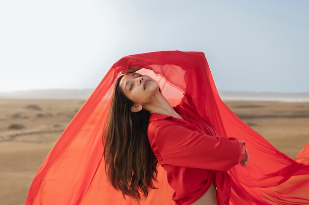 Medium shot woman throwing red scarf