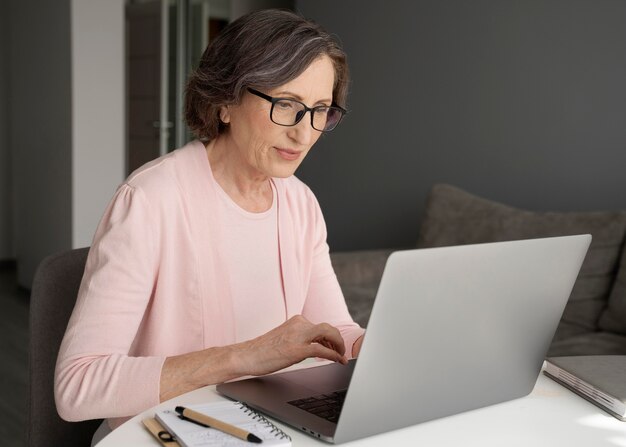 Medium shot woman typing on laptop