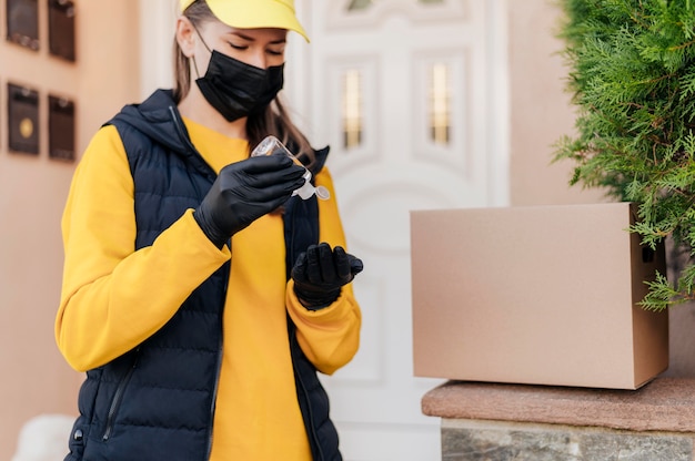 Foto gratuita donna del colpo medio che utilizza disinfettante