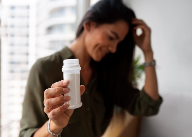 Foto gratuita donna di tiro medio che usa shampoo a secco a casa