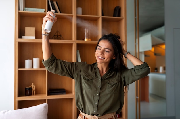 Foto gratuita donna di tiro medio che usa shampoo a secco a casa