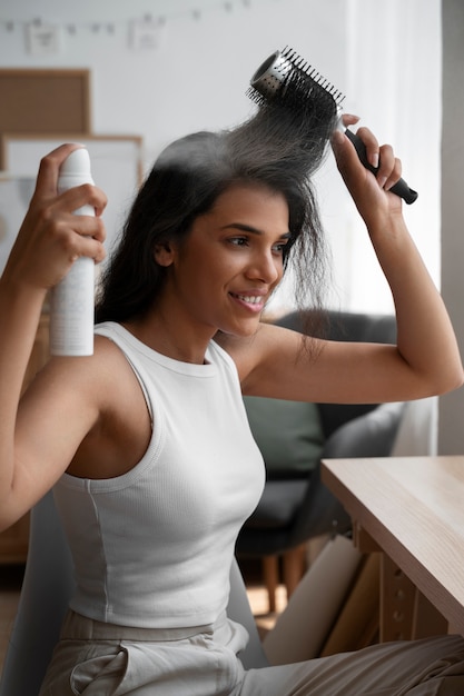 Foto gratuita donna di tiro medio che usa shampoo a secco a casa