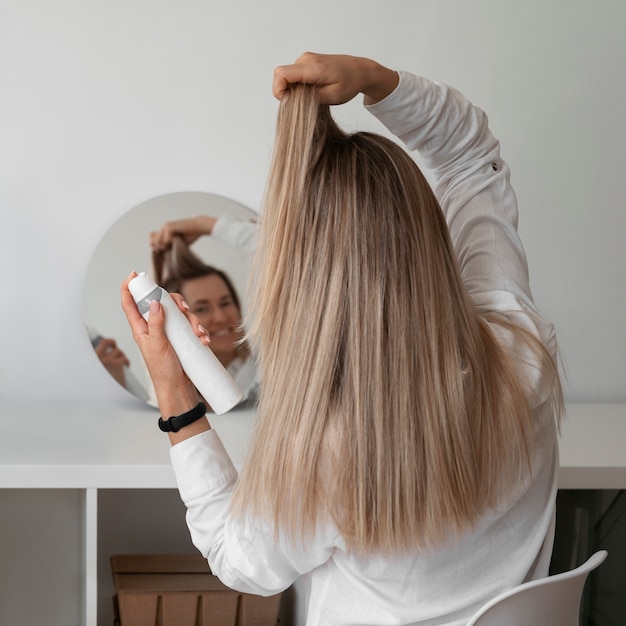 Donna di tiro medio che usa shampoo a secco a casa