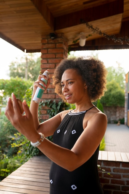 Free photo medium shot woman using dry shampoo