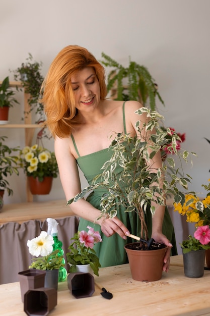 Foto gratuita donna del colpo medio che usa l'attrezzo di giardinaggio