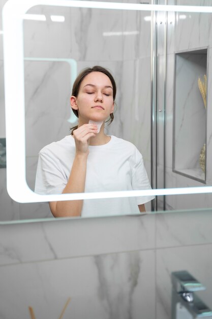 Medium shot woman using gua sha tool