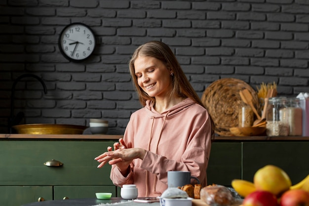 Medium shot woman using hand cream