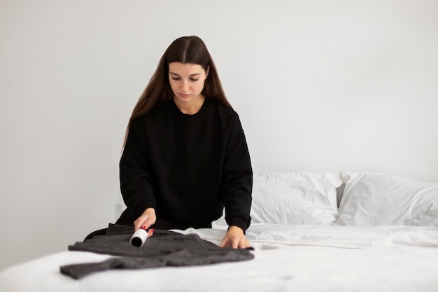 medium shot woman using lint roller