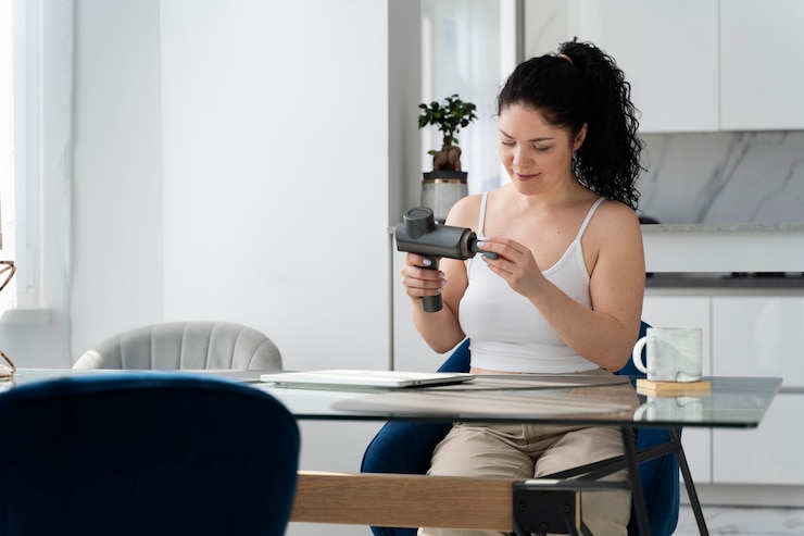 Free Photo medium shot woman using massage gun