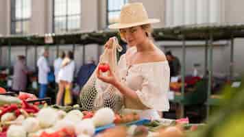 Foto gratuita donna di tiro medio che utilizza borsa organica per verdure