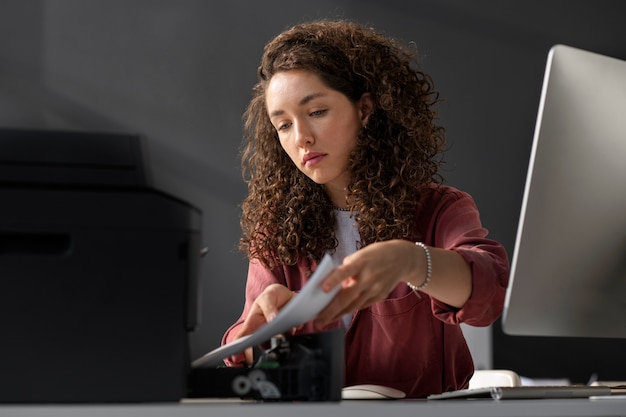 Medium shot woman using printer at work