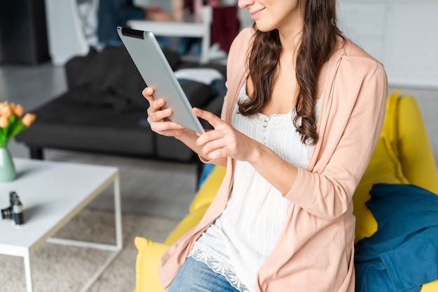 Free photo medium shot of woman using a tablet indoors