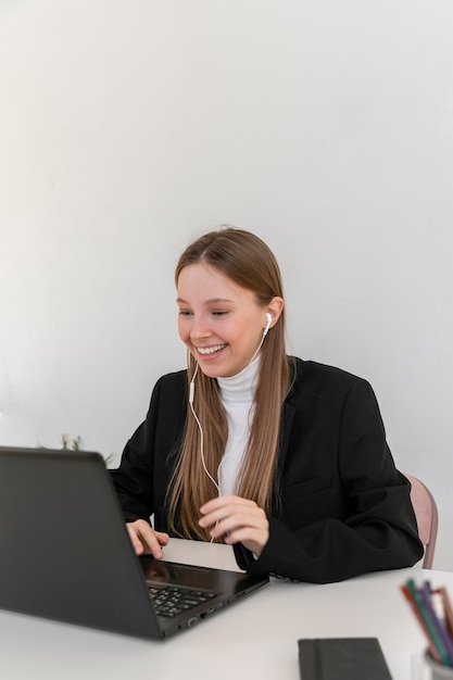 Medium shot woman videocalling at job