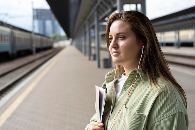 電車を待っているミディアムショットの女性