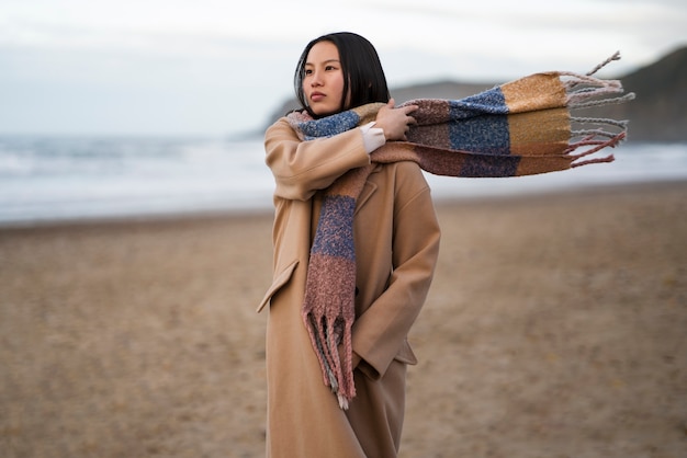 Free photo medium shot woman walking on the beach