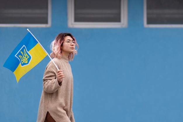 Free photo medium shot woman walking with ukrainian flag