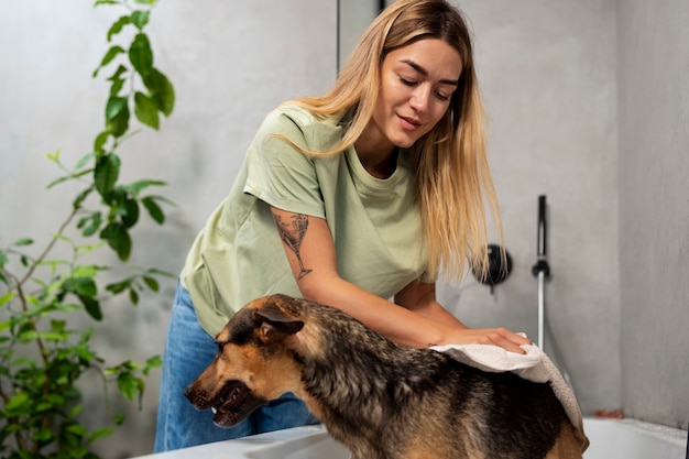 Free photo medium shot woman washing dog