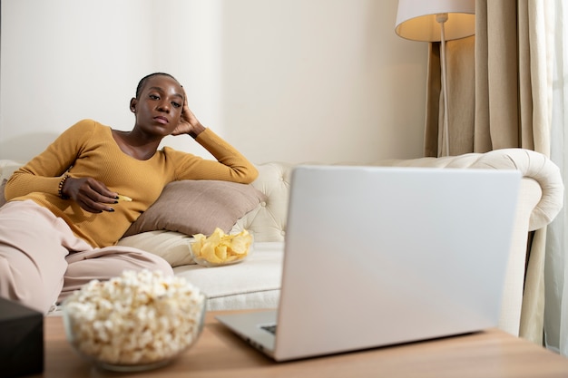 노트북으로 영화를 보고 있는 미디엄 샷 여성