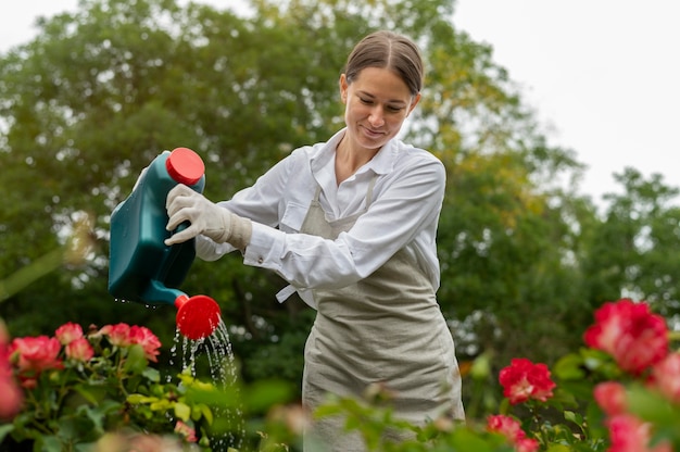 Medium shot woman watering flowers