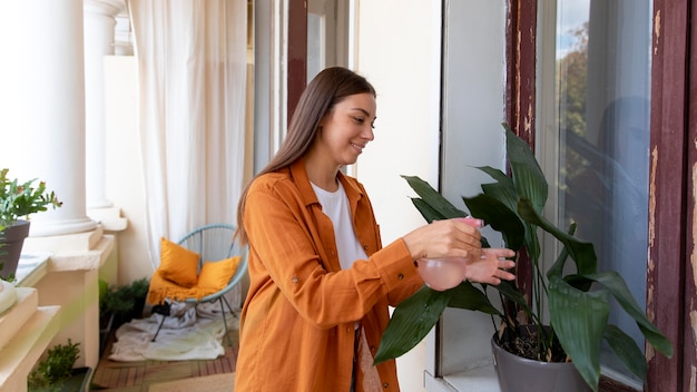 無料写真 ミディアムショットの女性の散水植物